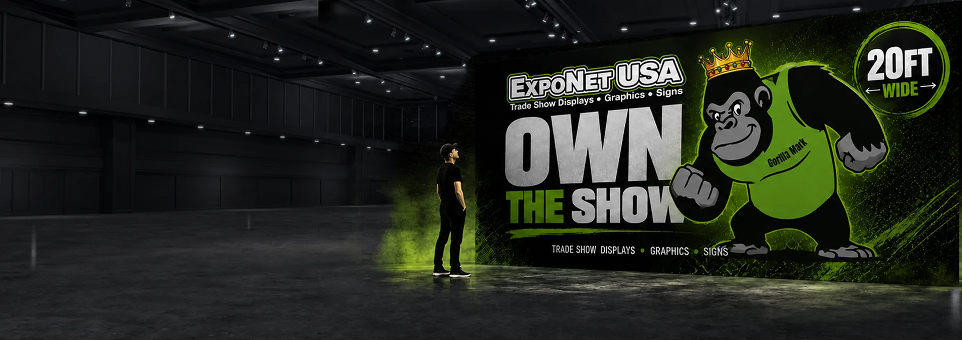 A 20ft ExpoNet USA Own The Show fabric backdrop with the crowned gorilla mascot, displayed in an empty convention hall